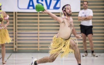 Ein Mann in Hula Kostüm der Völkerball spielt